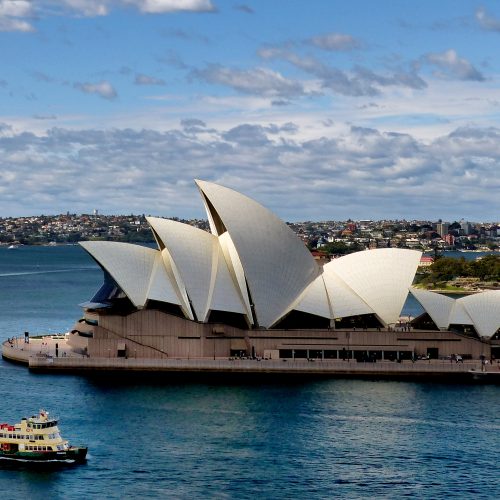 Sydney Opera House and Harbour Bridge seen across the water at dusk