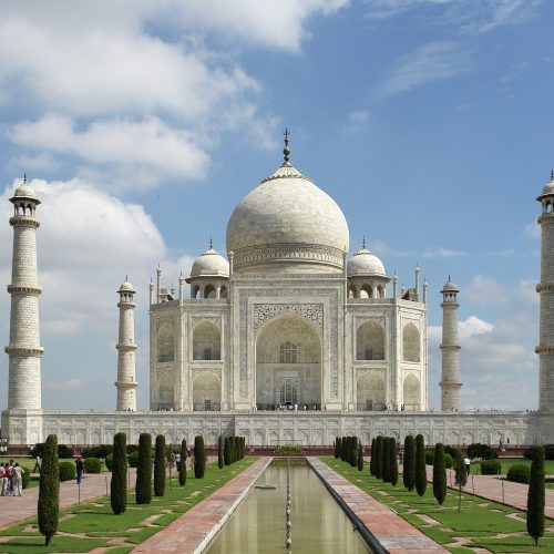 The Taj Mahal reflected in its garden pool at sunrise in Agra