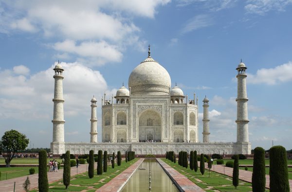 The Taj Mahal reflected in its garden pool at sunrise in Agra